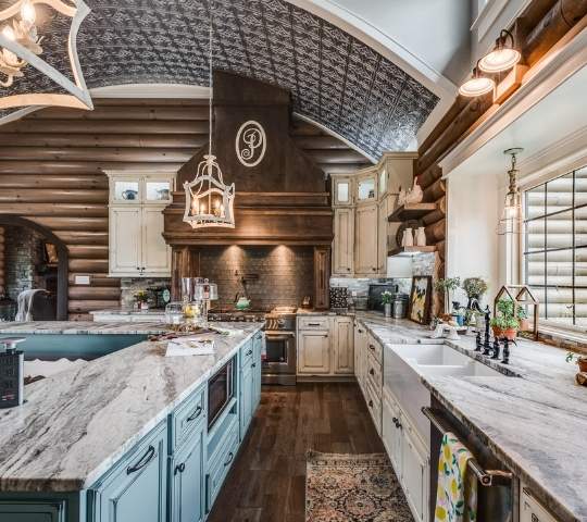 photo of stunning farmhouse kitchen with marble countertops and arch tiled ceiling, wood flooring and long prep spaces